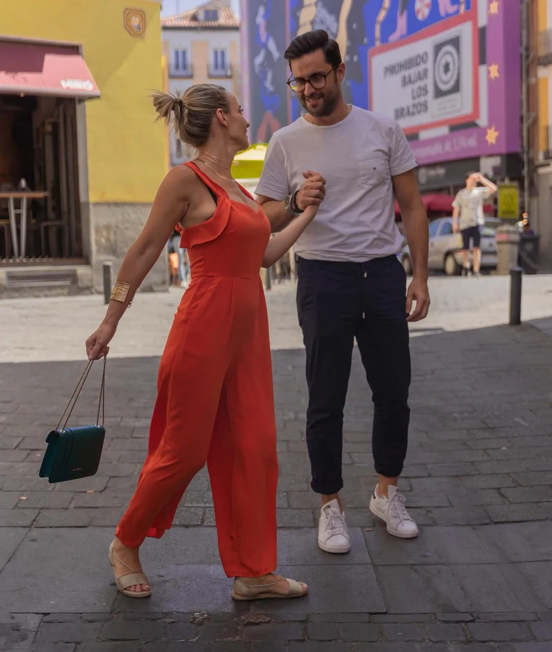 Sesión de pareja en Madrid — pareja paseando de la mano por una calle empedrada, retrato urbano