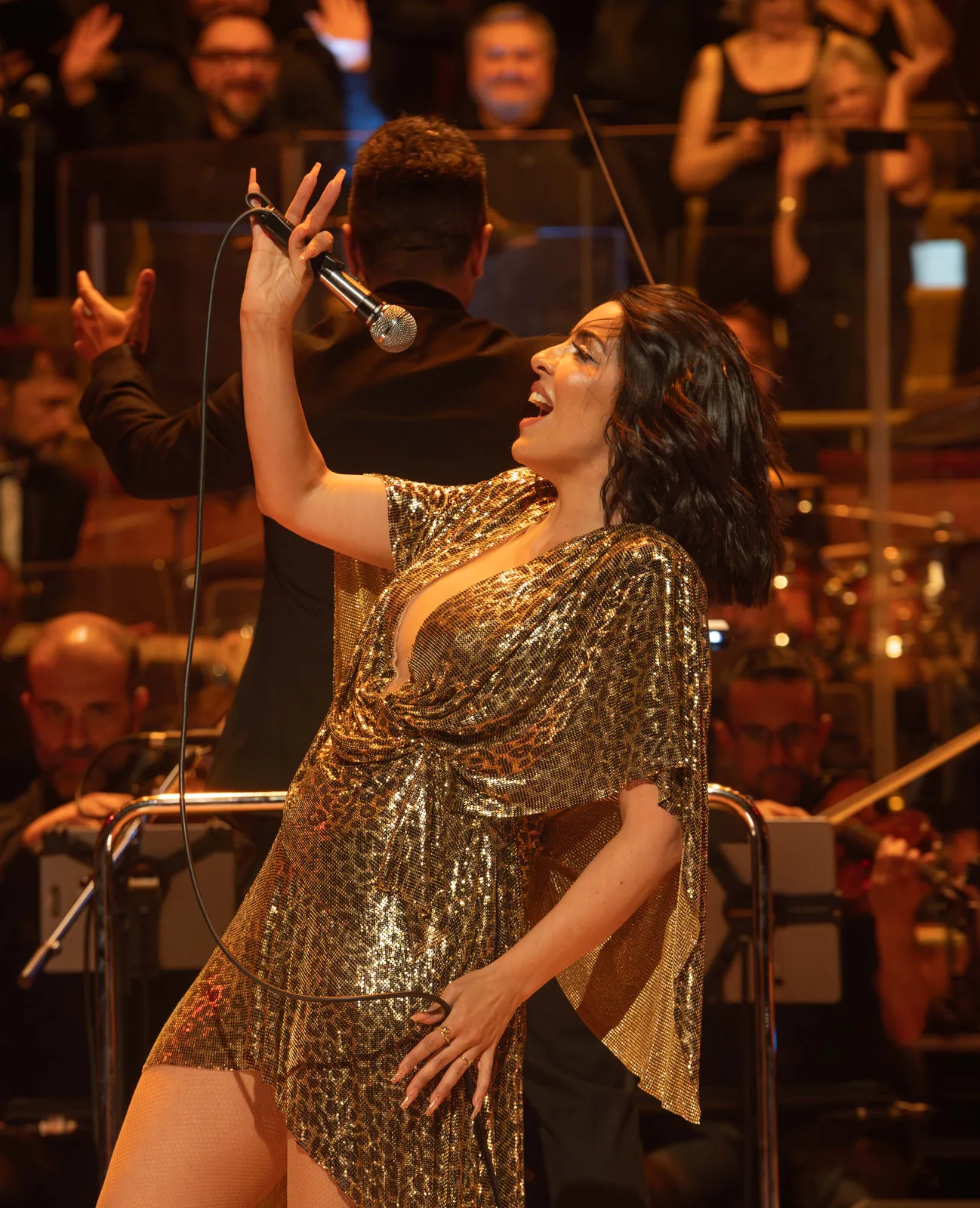 Cantante con vestido dorado en concierto en Madrid