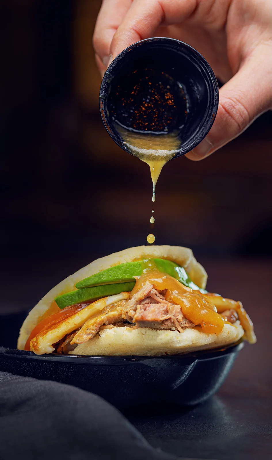 Salsa vertida sobre bao — fotografía gastronómica de acción en Madrid — Roberto Romero