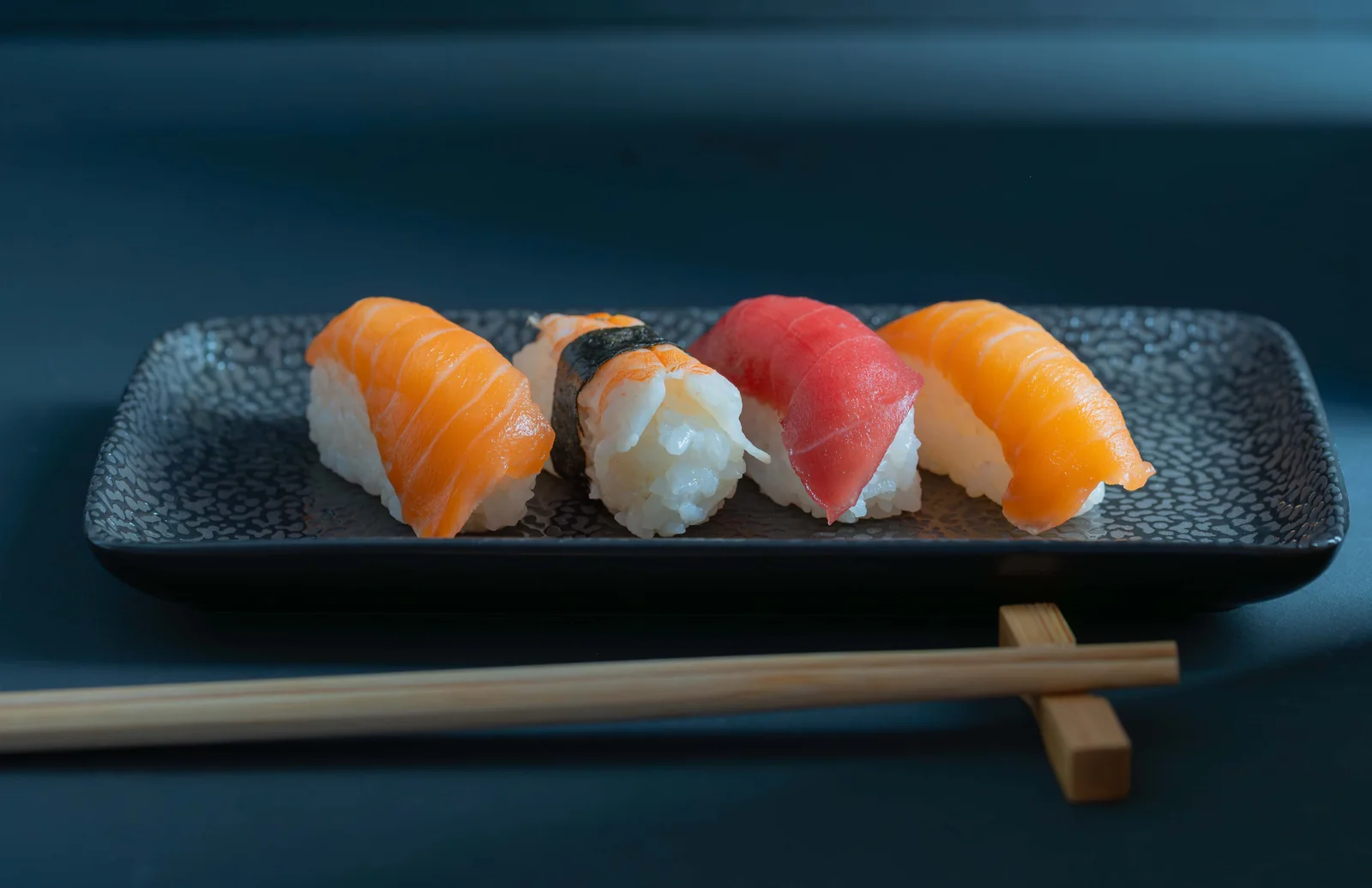 Nigiris de salmón y atún sobre fondo azul — fotografía gastronómica editorial — Roberto Romero