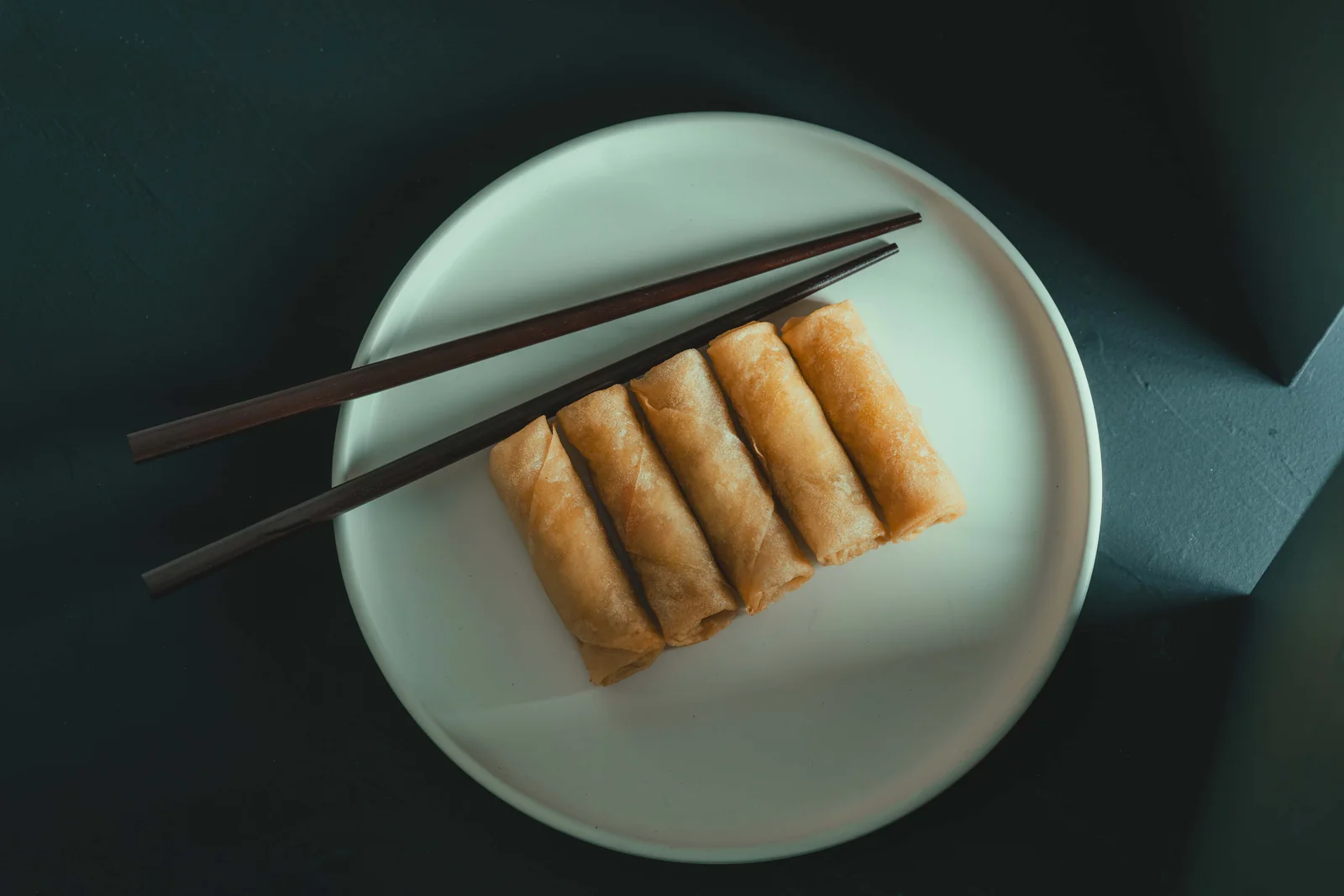 Rollitos en plato turquesa con palillos — fotografía gastronómica en Madrid — Roberto Romero